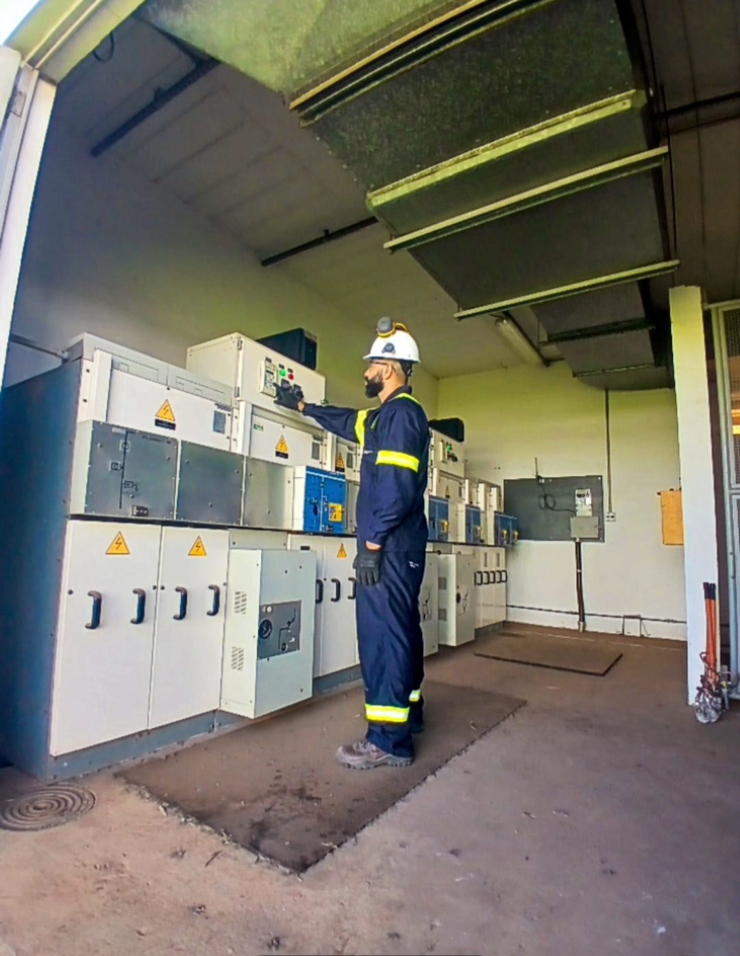 Profissional realizando manutenção em cabine de média tensão