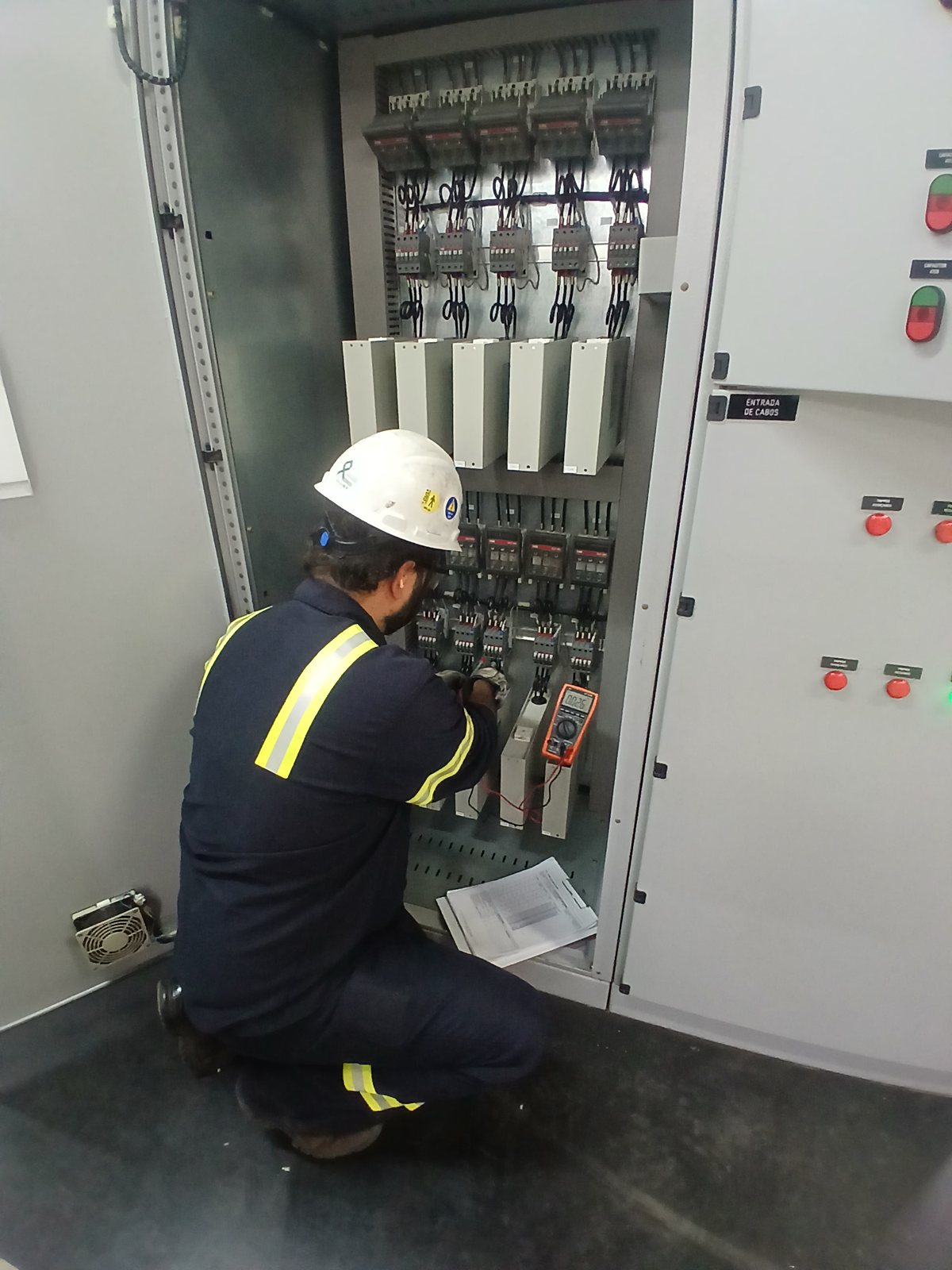 Profissional verificando componentes de um painel